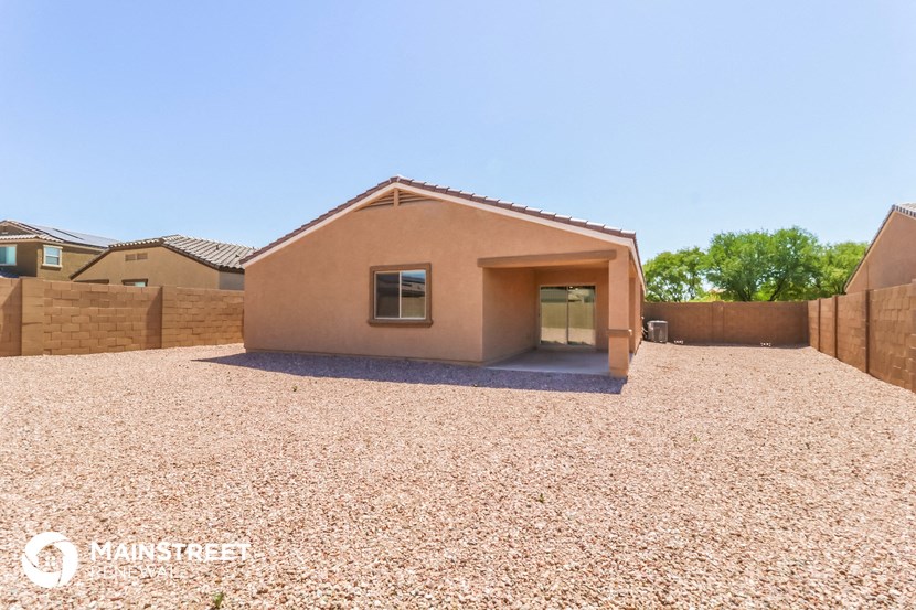 a side view of a house with a gravel driveway