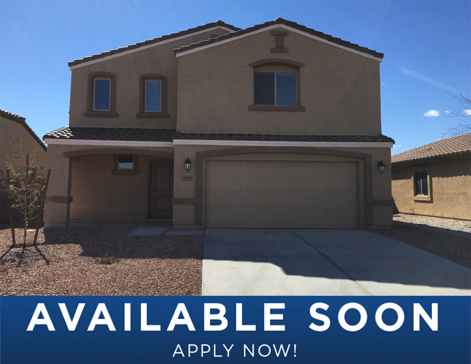 a tan house with a garage door and a sign that reads
