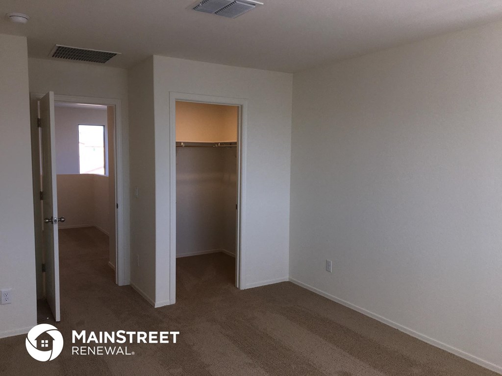 a bedroom with a closet and a door to a hallway