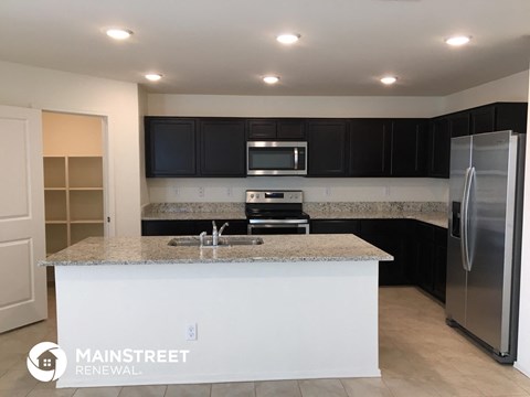 a kitchen with black cabinets and a granite counter top