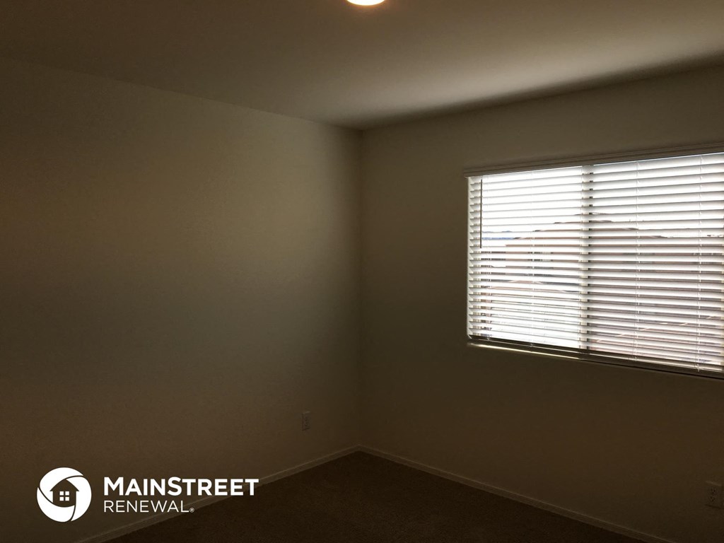 the corner of a room with a window and blinds