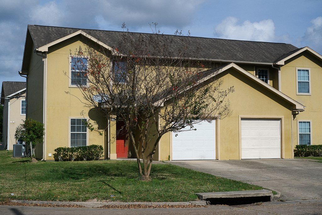a yellow house with a white garage door