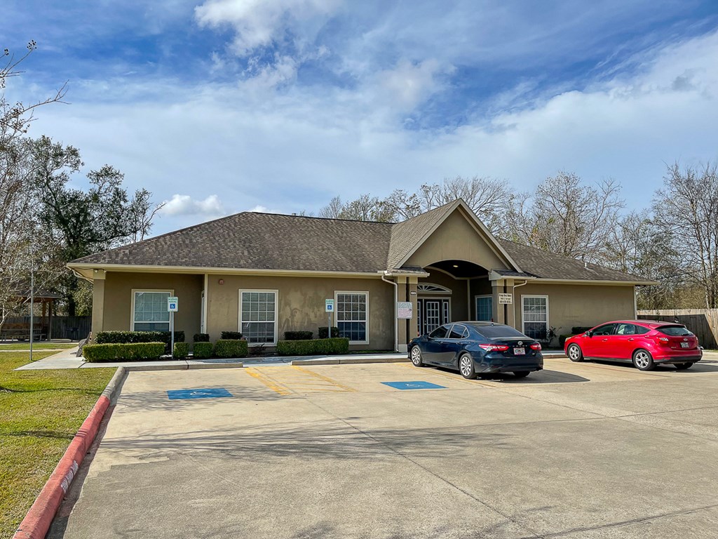 a house with a parking lot and two cars in front of it