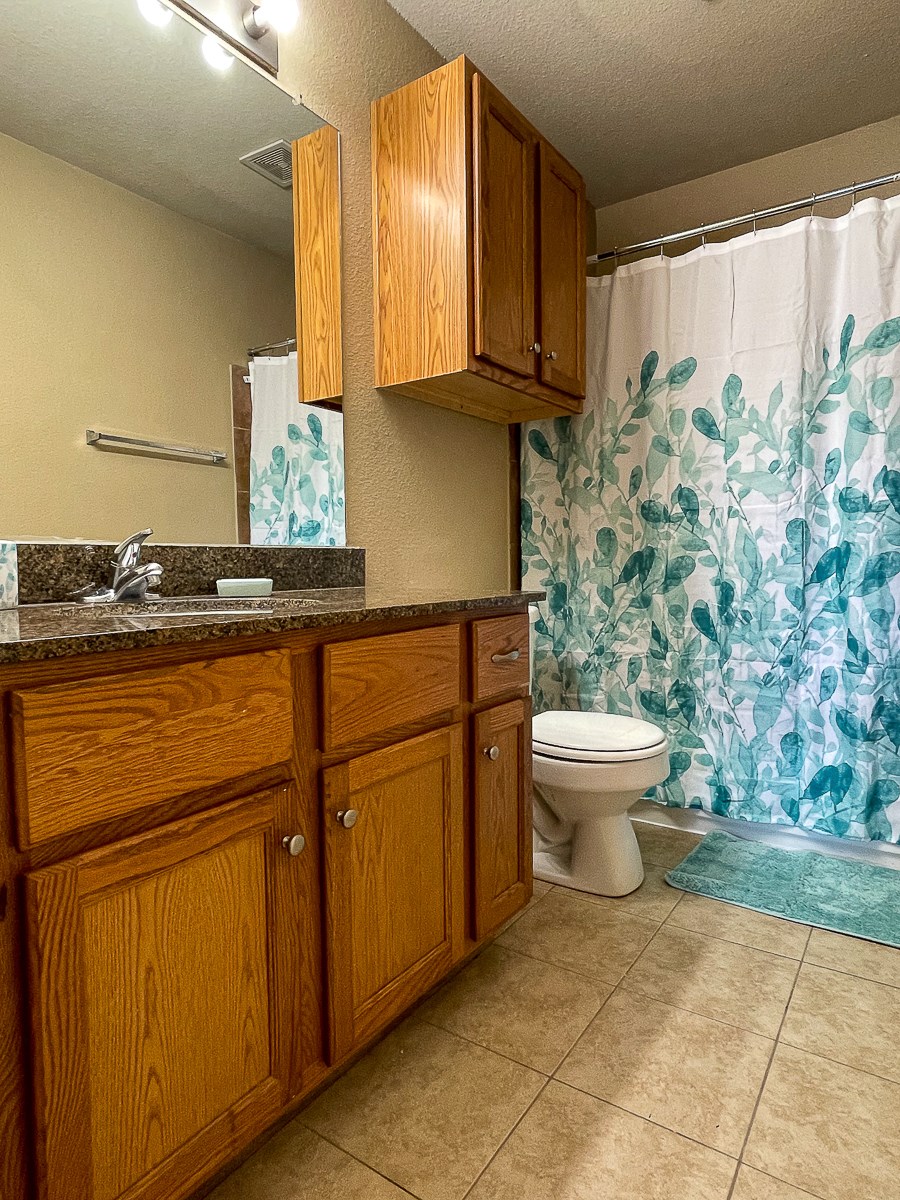 a bathroom with a toilet and a shower curtain
