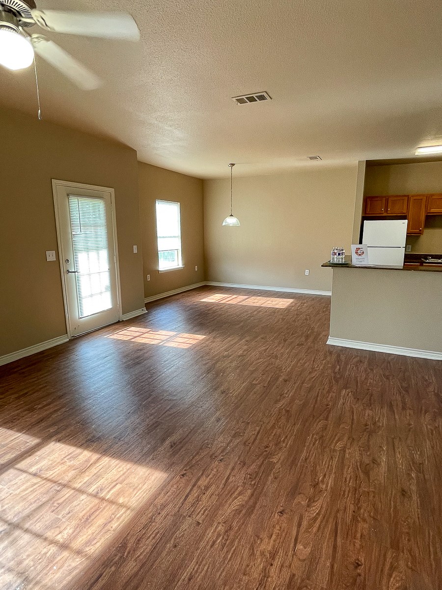 an empty living room with a hard wood floor