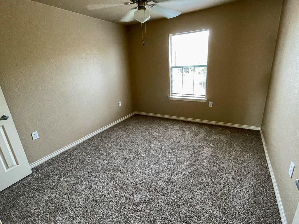 an empty room with carpet and a window
