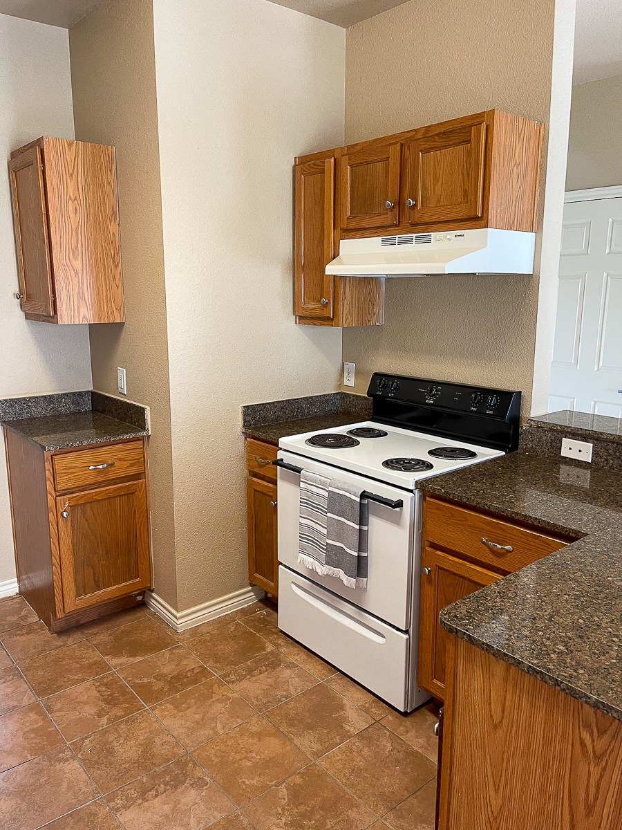 a kitchen with a stove and a microwave and wooden cabinets