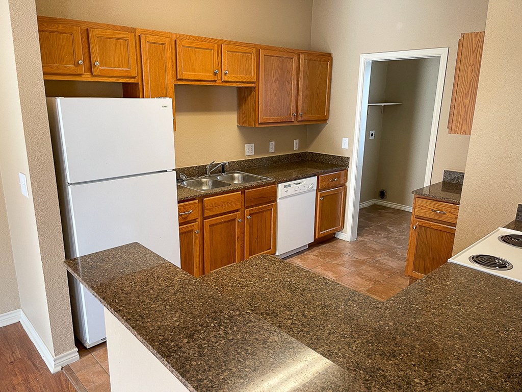 a kitchen with white appliances and granite counter tops