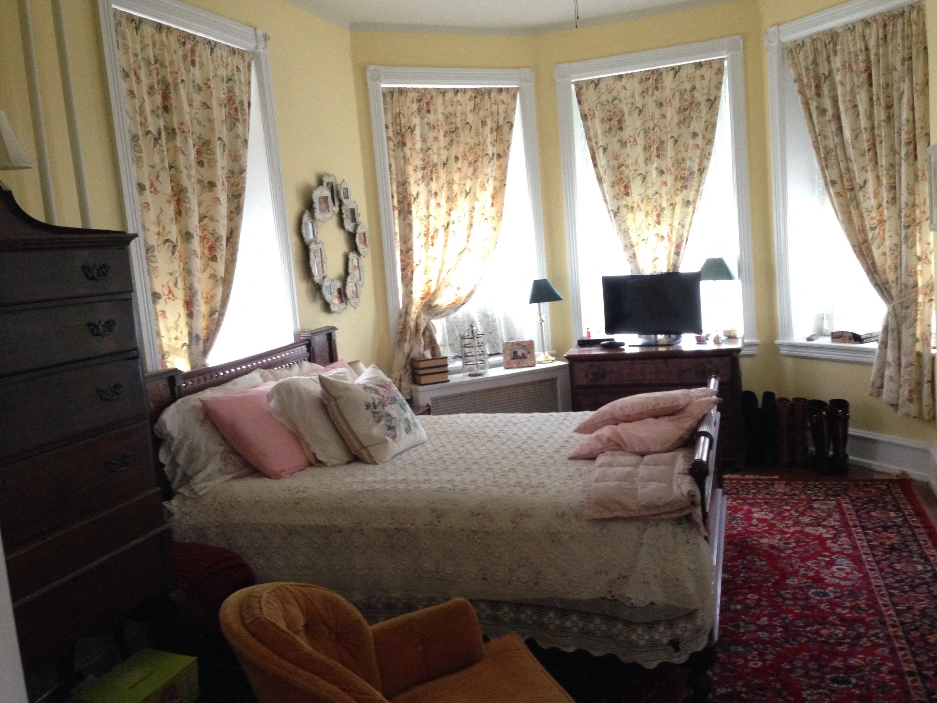 a bedroom with a bed and three windows