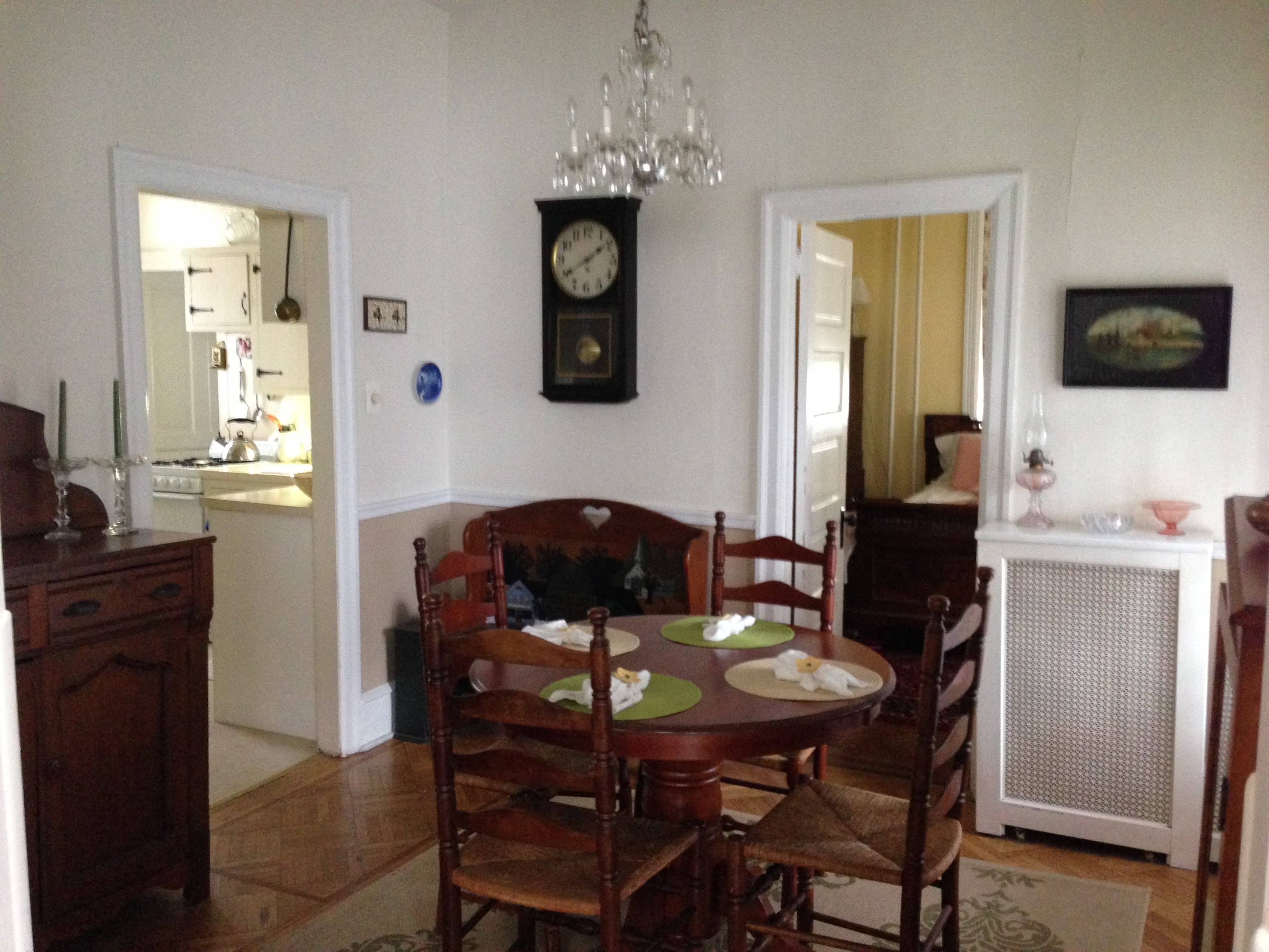 a dining room with a table and chairs and a clock on the wall