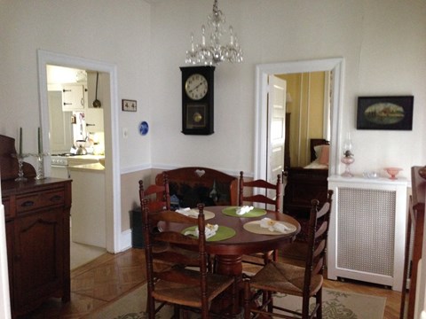 a dining room with a table and chairs and a clock on the wall