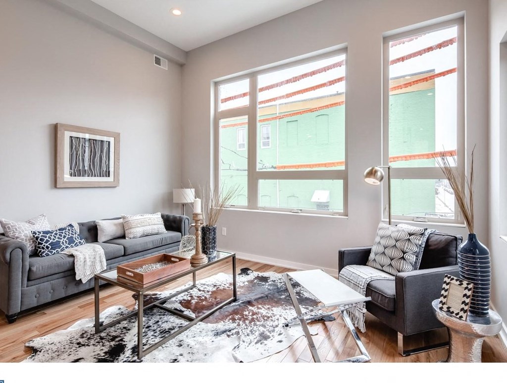 a living room with two windows and a couch and a table