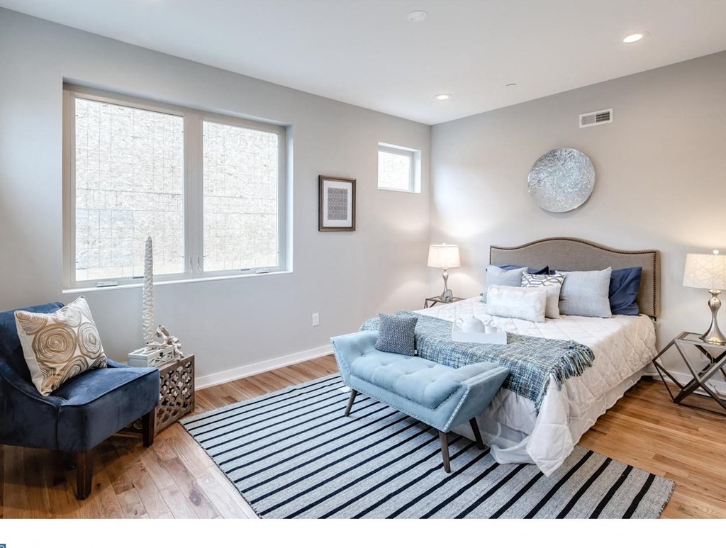 a bedroom with a bed and two windows