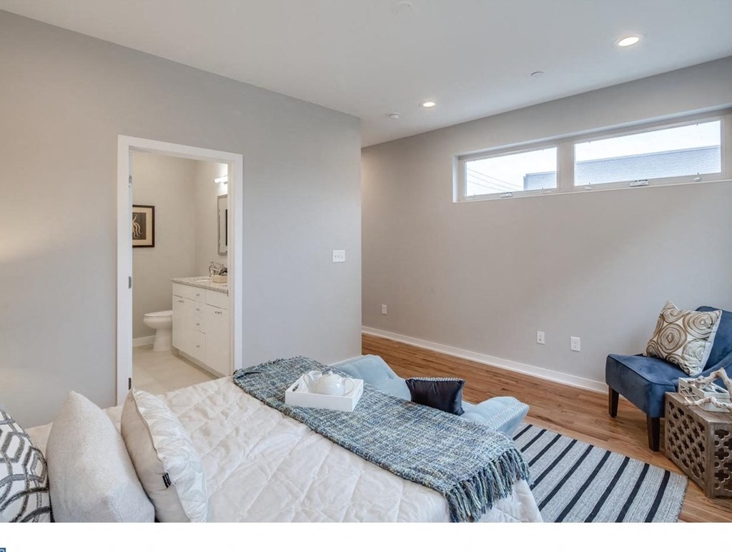 a bedroom with a bed and a bathroom with a sink