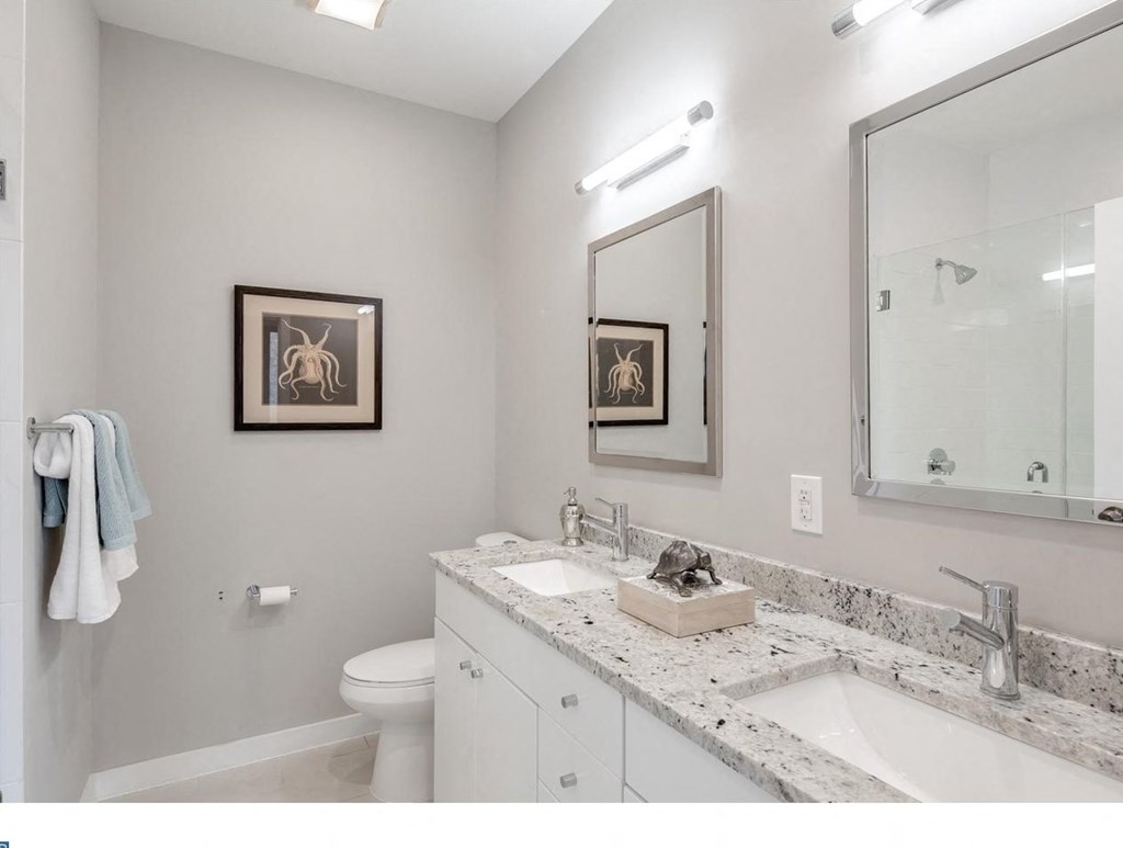 a bathroom with two sinks and a mirror and a toilet