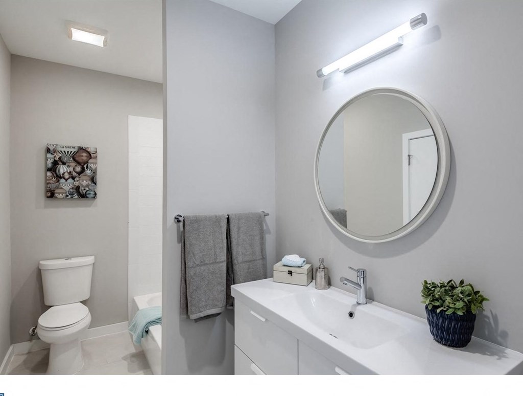 a bathroom with a mirror and a sink and a toilet