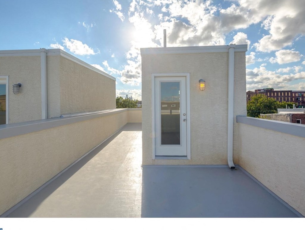 a small white building with a white door on a roof