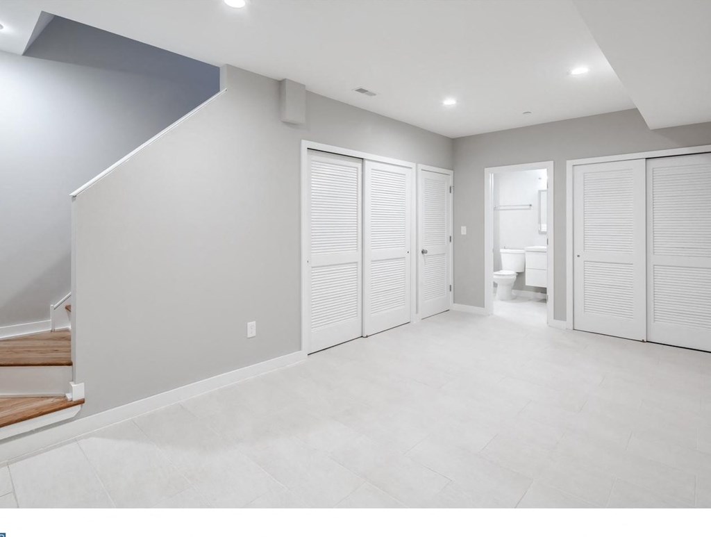 a white room with white shutters on the closet doors
