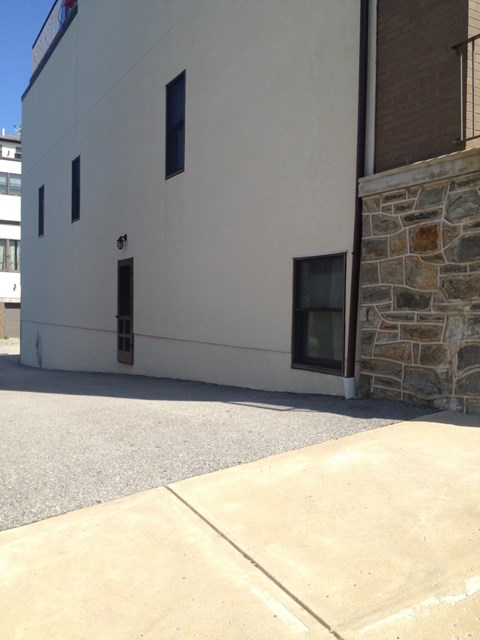 A white building with a stone pillar on the side.