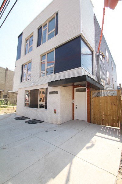 a white and blue apartment building with a sidewalk