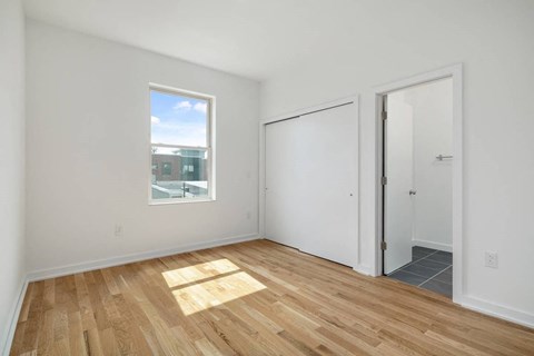 an empty living room with a window and a door to a closet