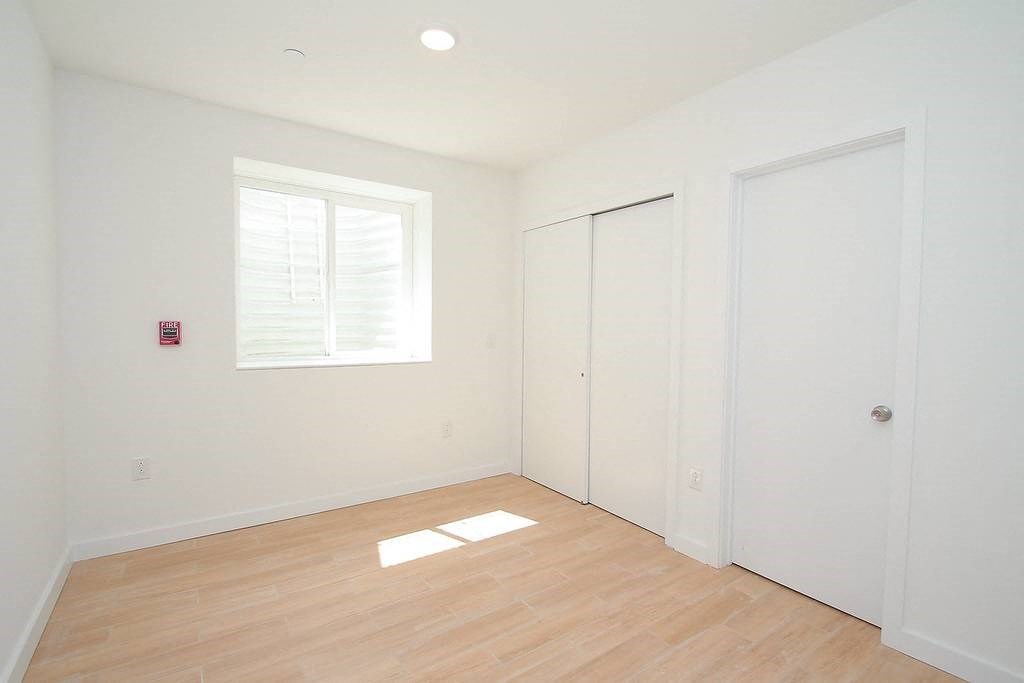 an empty room with white walls and a window