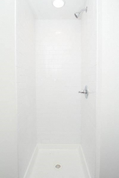 a white shower in a bathroom with a shower head