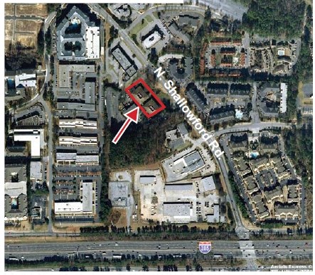 an aerial view of a city with a red arrow pointing to a building