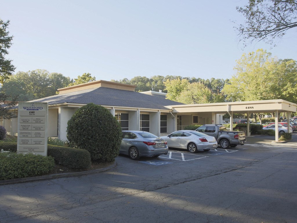 a parking lot with cars in front of a building
