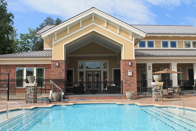 a swimming pool in front of a building with a resort style pool