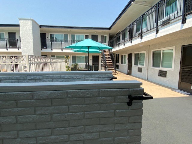 a patio with an umbrella and a brick wall