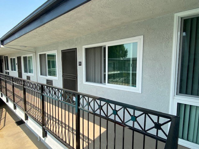 a balcony of a building with windows and a black railing