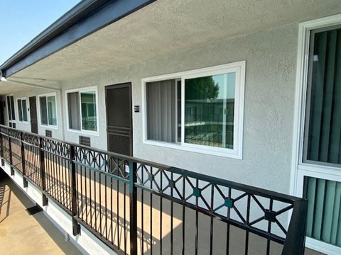 a balcony of a building with windows and a black railing