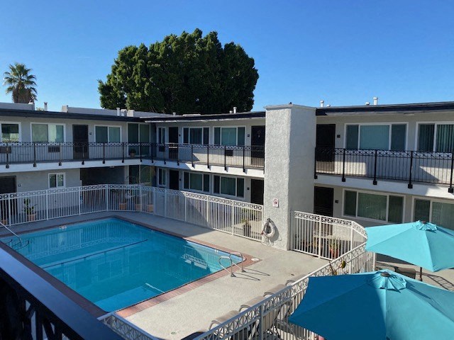a swimming pool and a building with umbrellas