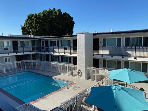 a swimming pool and a building with umbrellas