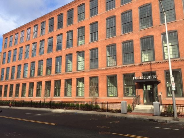 Capitol Lofts building brick mill building exterior with large windows - Photo Gallery 1