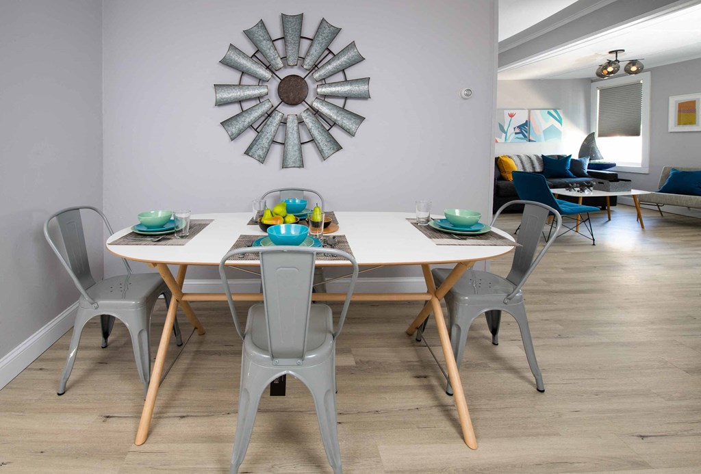 a dining room with a table and chairs and a mirror on the wall