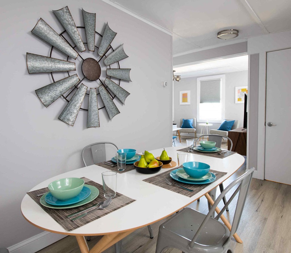 a dining room with a table and chairs and a mirror on the wall