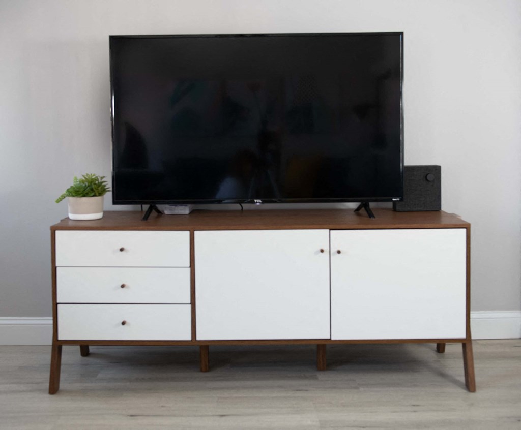 a television sits on top of a white dresser