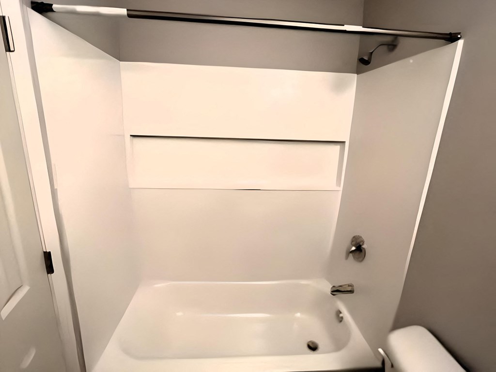 a white bathroom with a tub and a sink