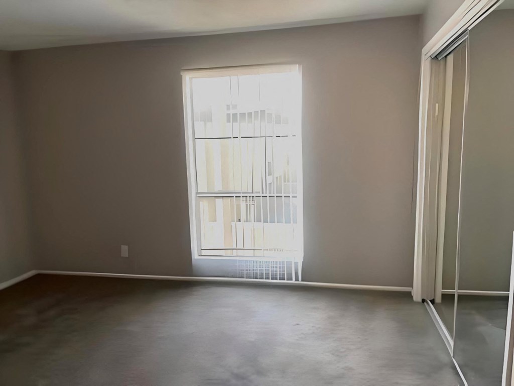 an empty living room with a window and a door