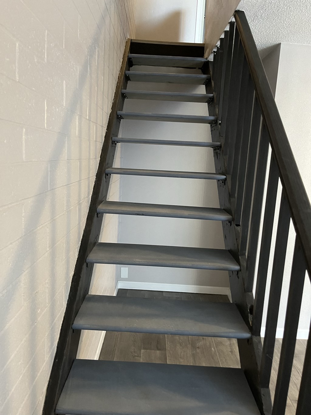 a set of stairs with a wooden railing and a white wall