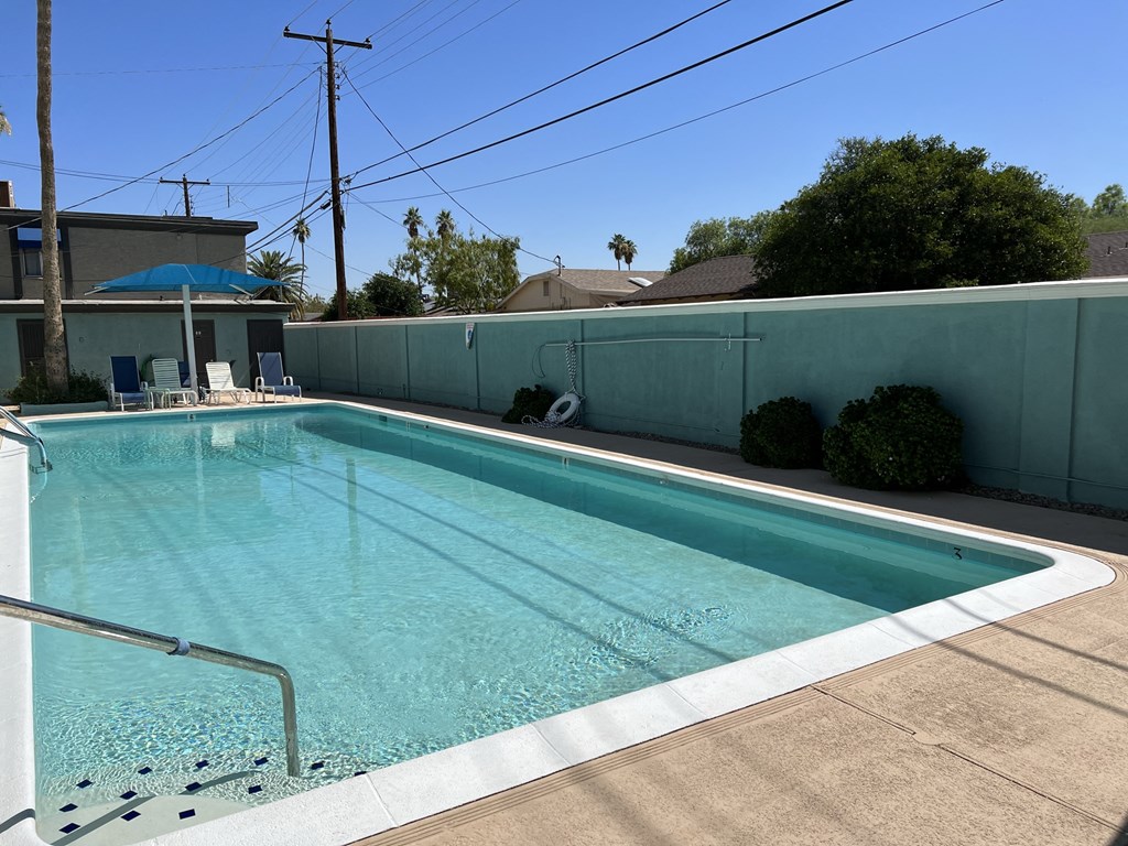 a swimming pool in a backyard next to a blue fence