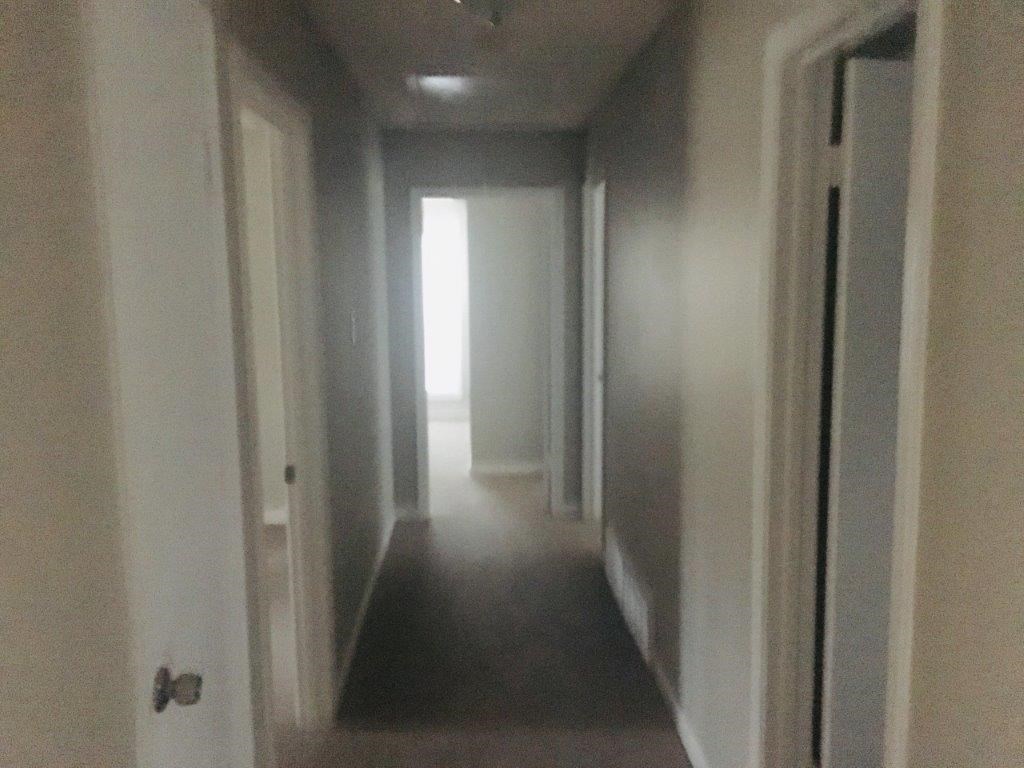 a hallway with white walls and white doors and a white hallway with a white door