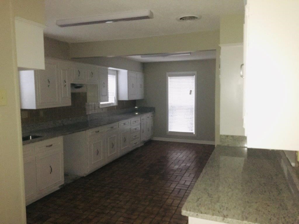 an empty kitchen with white cabinets and counter tops