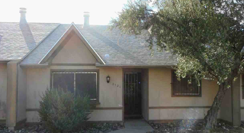 A house with a black door and a small window is shown.