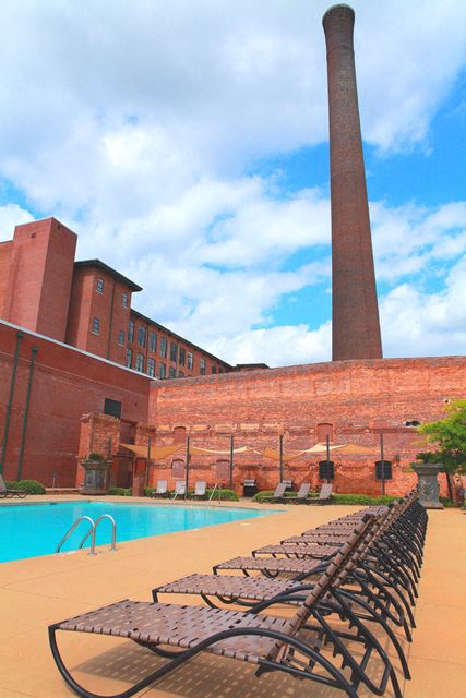 a row of chaise lounge chairs next to a swimming pool in front of a