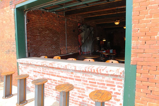 a brick bar with wooden stools in front of a window