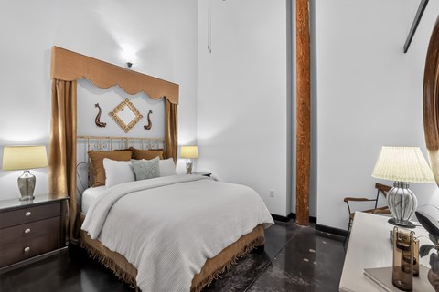 A bedroom with a large bed and a wooden headboard.