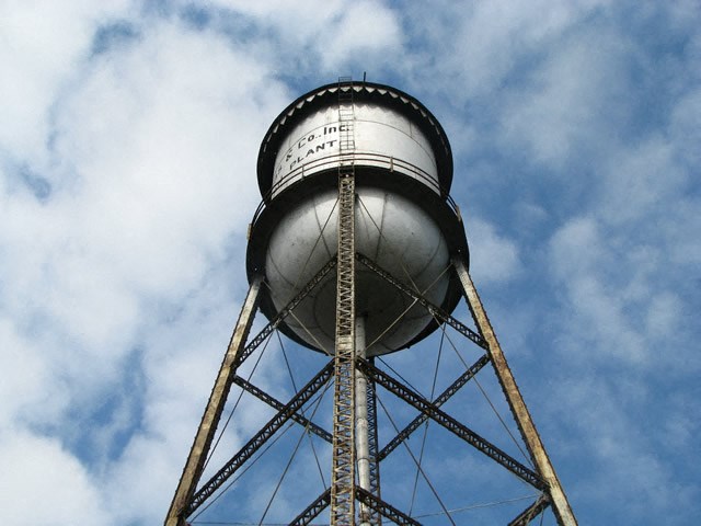 the top of a water tower against a cloudy sky